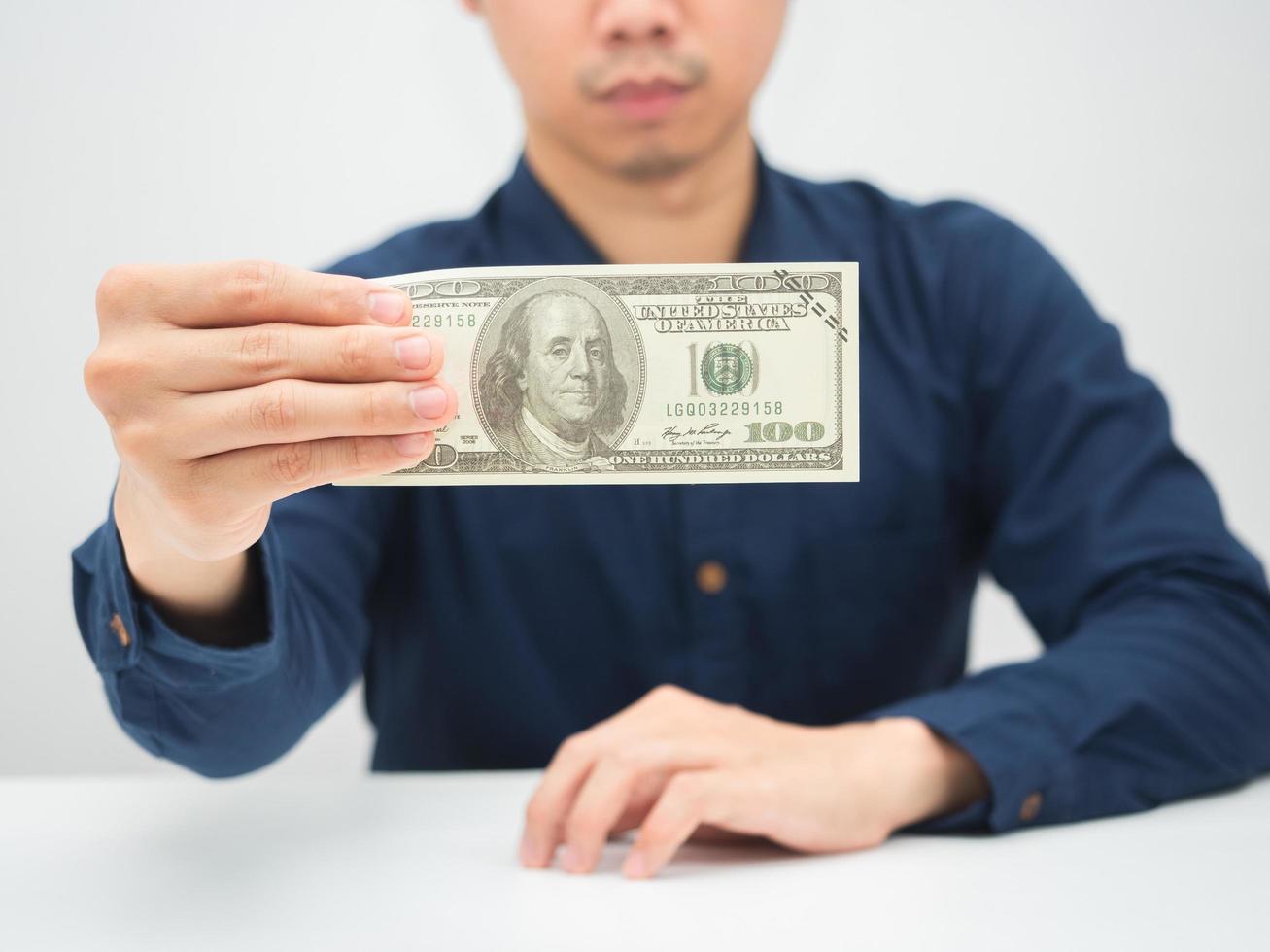 detailopname geld dollar in Mens hand- zittend Aan de bureau foto