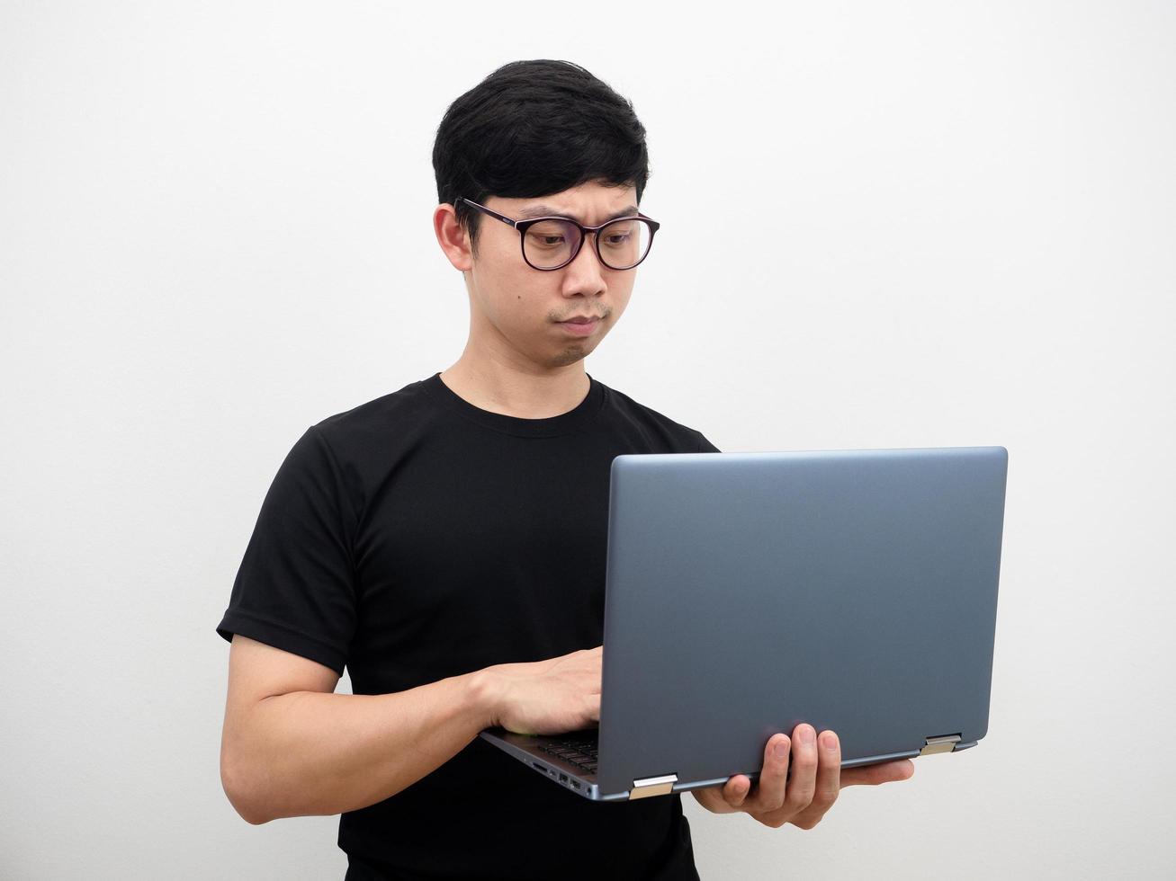 Aziatisch Mens vervelend bril gebruik makend van laptop in hand- echt gezicht Aan wit achtergrond foto