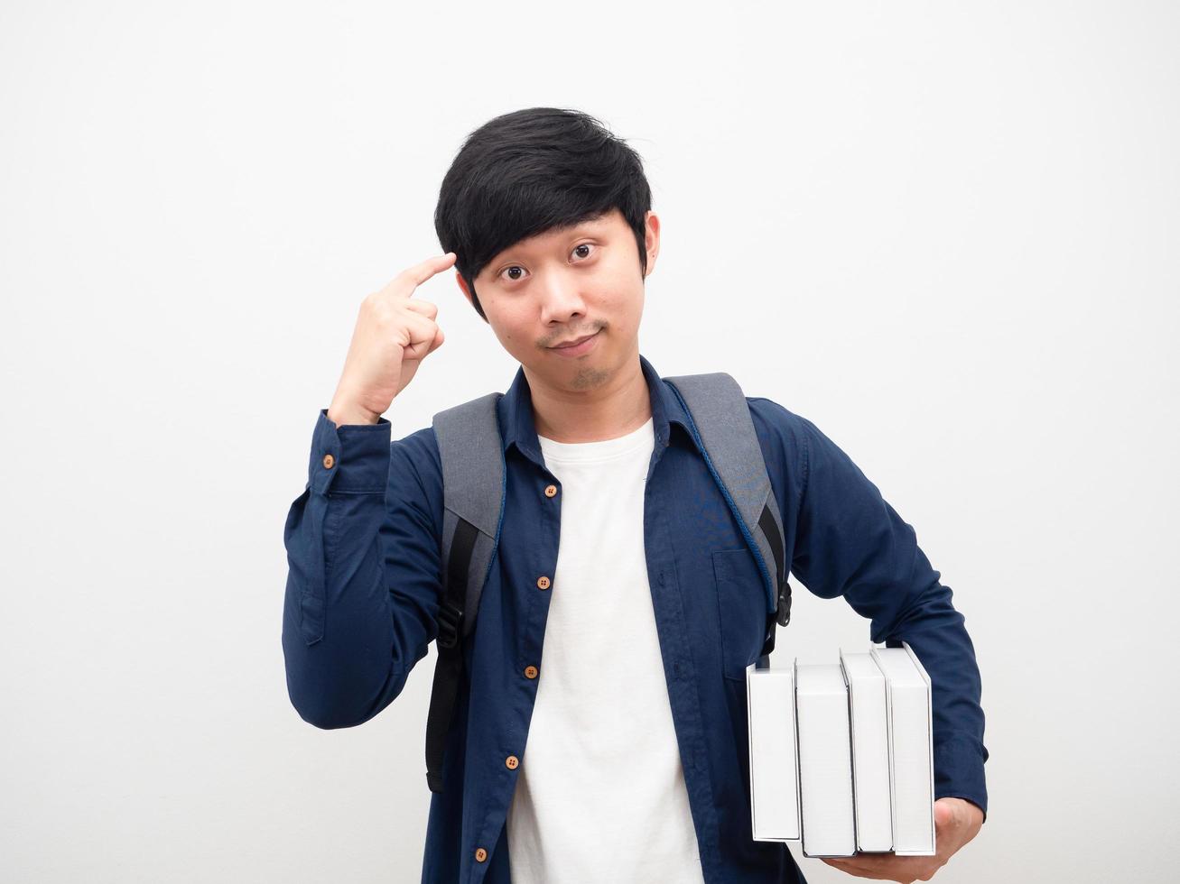 jong Mens met school- zak Holding boeken en punt Bij zijn hoofd voor denken wit achtergrond foto