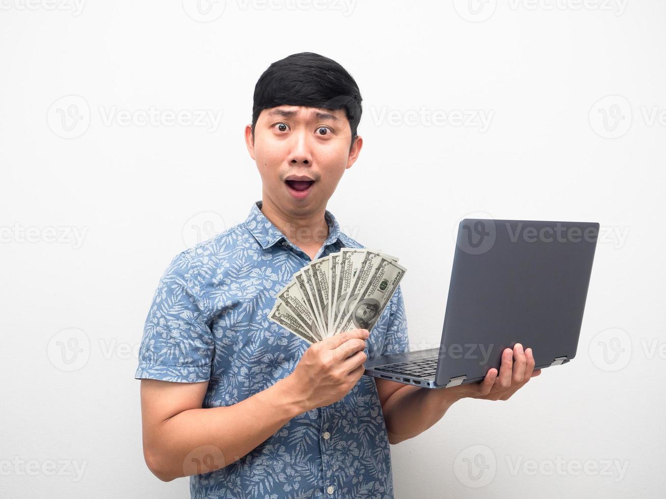 Aziatisch Mens blauw overhemd Holding laptop met een veel van geld opgewonden gezicht geïsoleerd foto