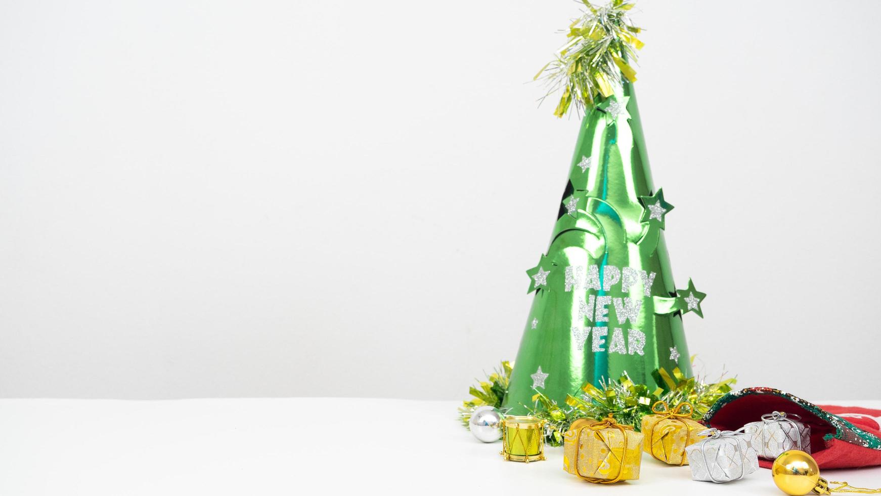 Kerstmis items met groen hoed gelukkig nieuw jaar concept Aan de tafel wit achtergrond kopiëren ruimte foto