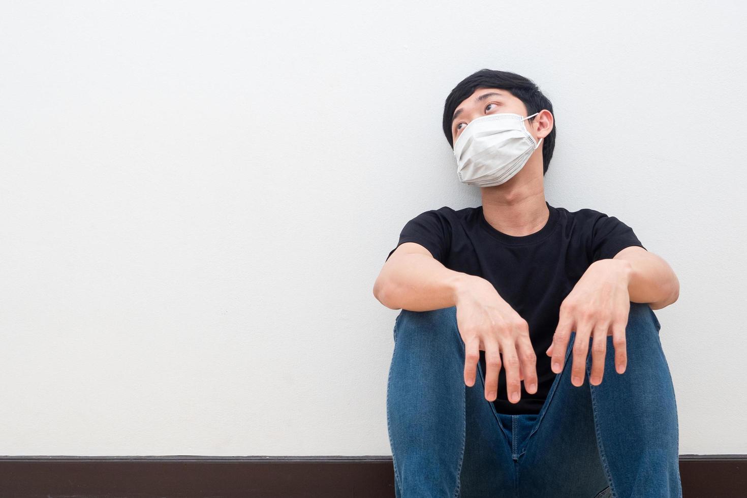 depressief Mens vervelend beschermen masker zitten tegen de muur verdrietig emotie foto