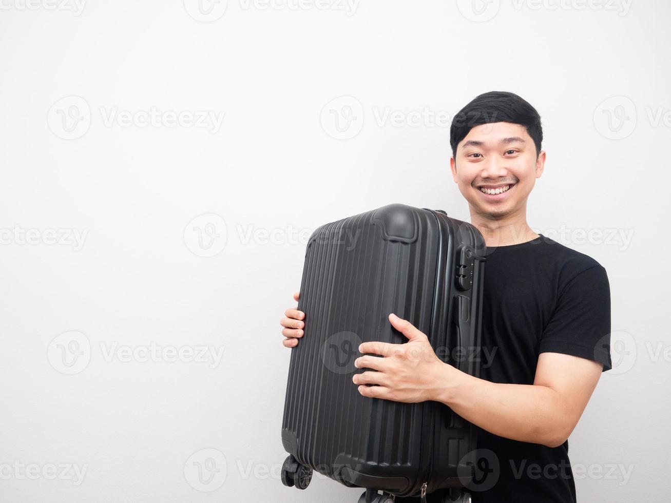Mens Holding bagage glimlachen vrolijk kopiëren ruimte foto