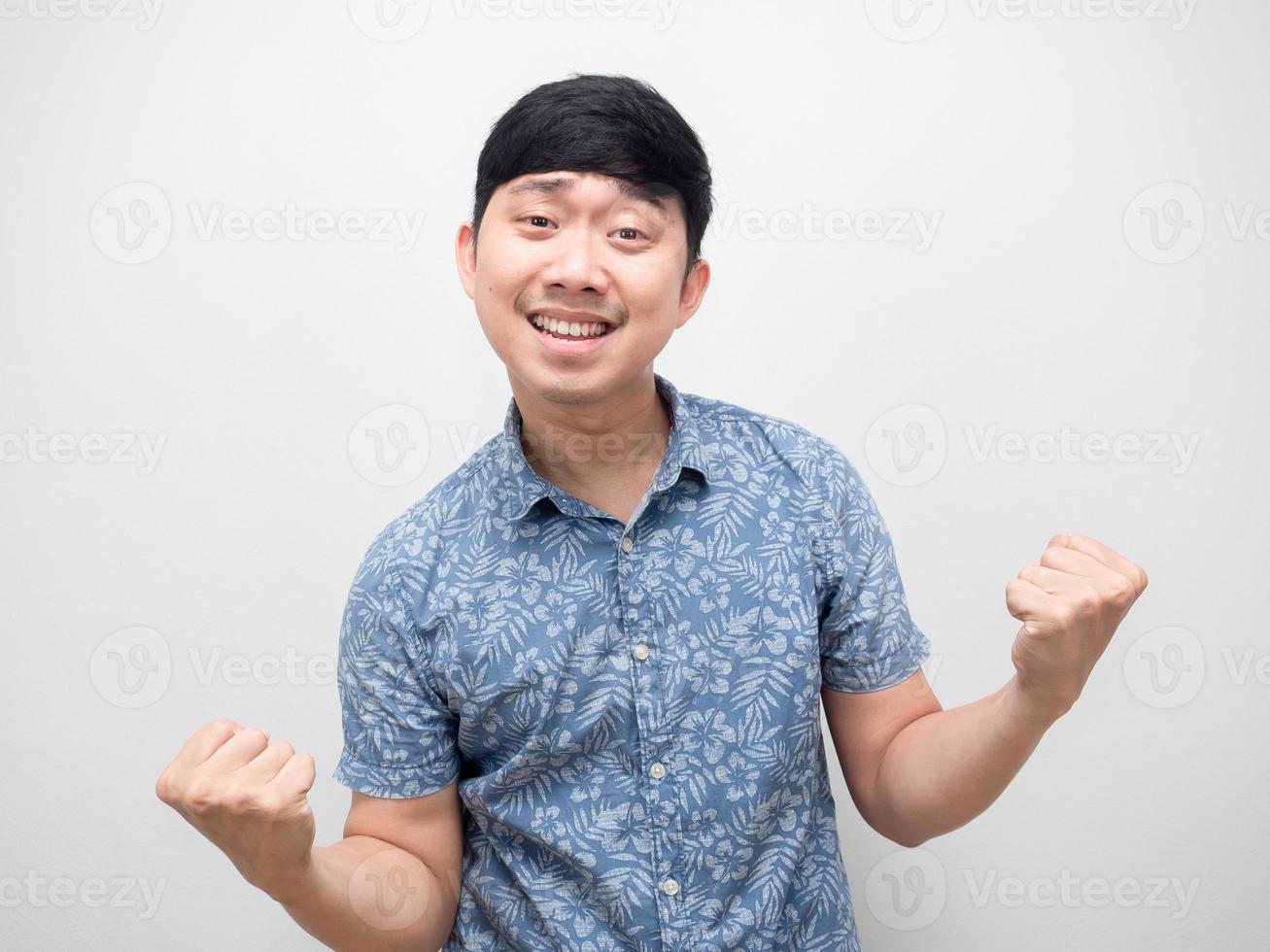 Aziatisch Mens blauw overhemd gebaar voldoen gelukkig emotie en vuist omhoog foto