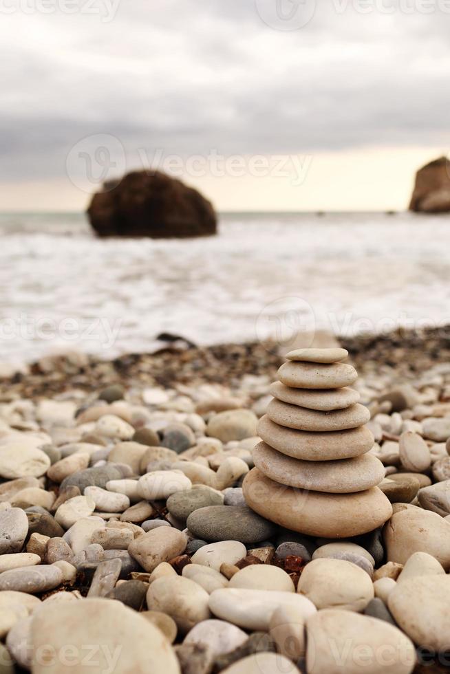 piramide stenen aan de kust op een zonnige dag op de achtergrond van de blauwe zee. fijne vakantie. kiezelstrand, kalme zee, reisbestemming. concept van gelukkige vakantie aan zee. foto