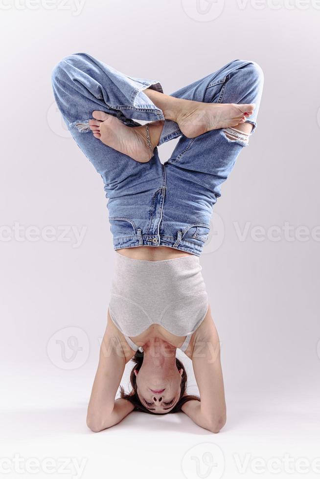 portret van mooi jong vrouw met atletisch flexibel lichaam aan het doen been uitrekken. geïsoleerd foto