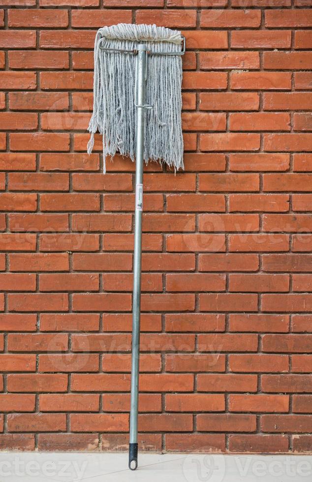 vuil dweilen tegen de oranje steen muur 2 foto