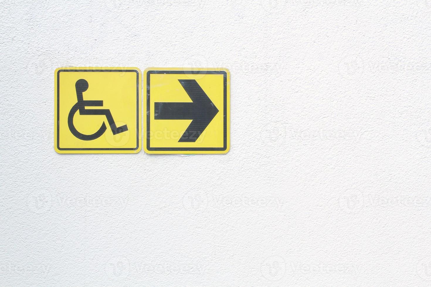 geel gehandicapt teken en pijl Rechtsaf richten teken Aan wit achtergrond. gehandicapten beschikbaar teken van rolstoel. concept van comfortabel traject voor mensen barrièrevrij stedelijk milieu in stad. foto