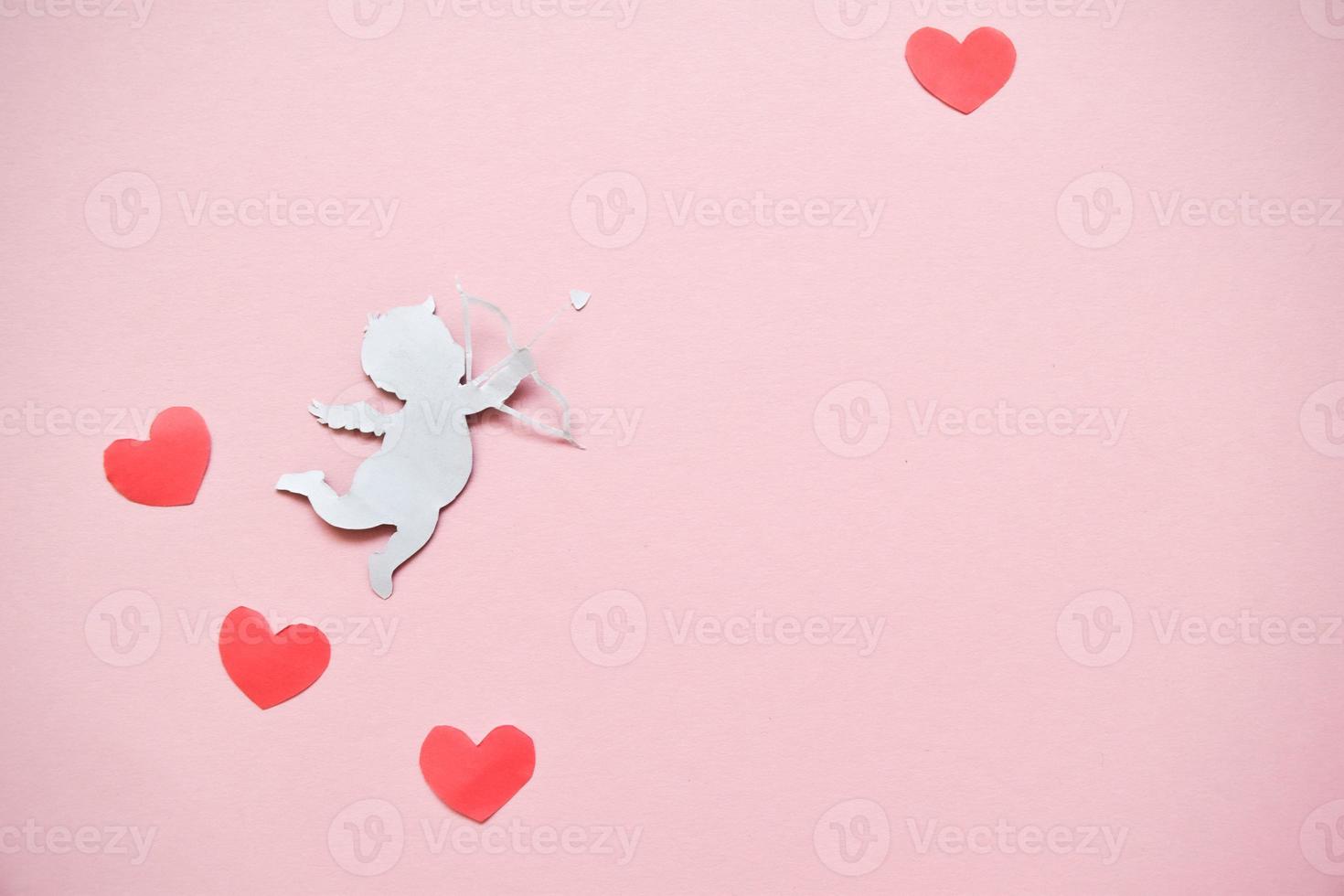 valentijnsdag dag begrip. rood kleur harten en Cupido het richten in hart Aan roze achtergrond. valentijnsdag dag kaarten. foto