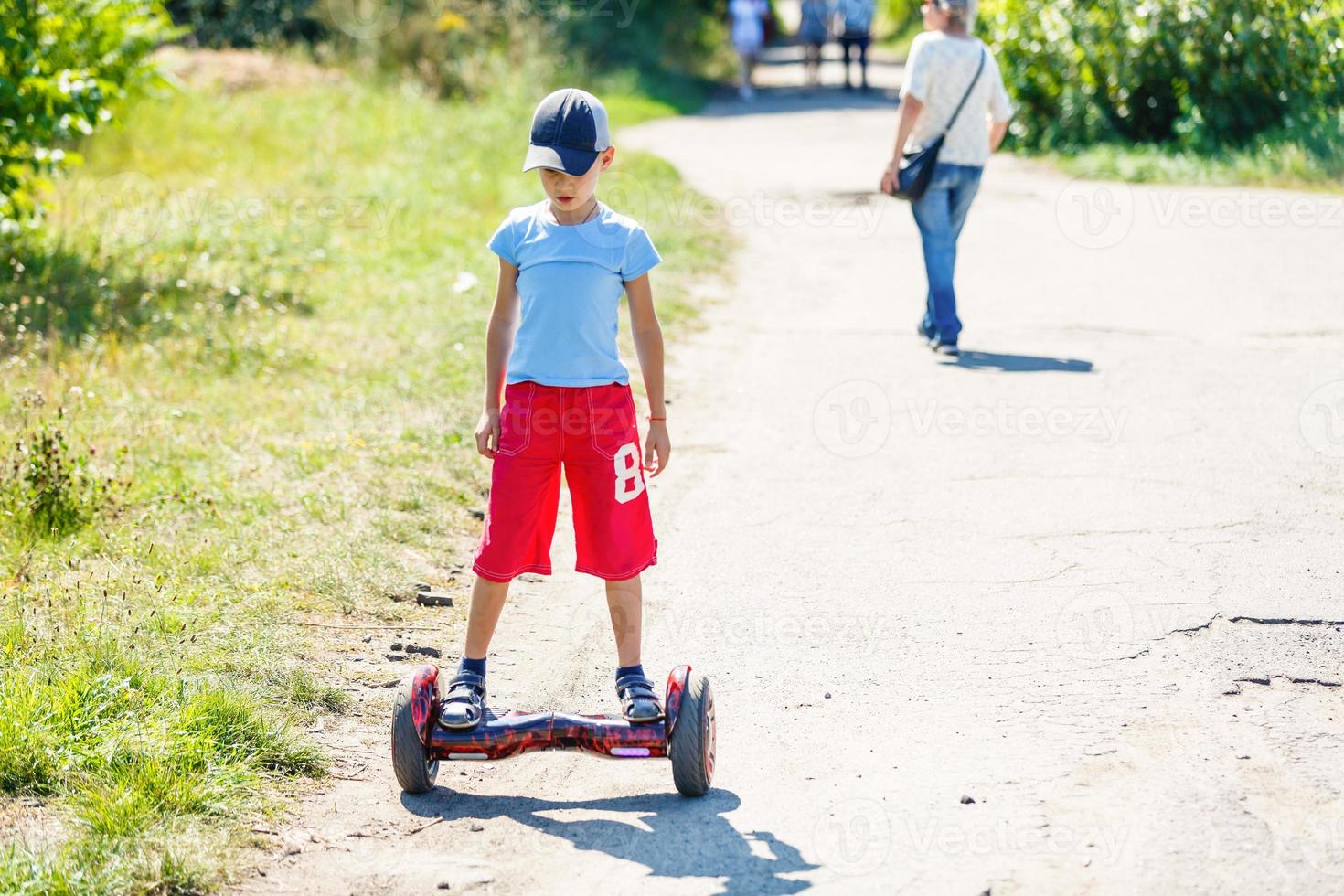 weinig jongen rijden elektrisch scooter foto