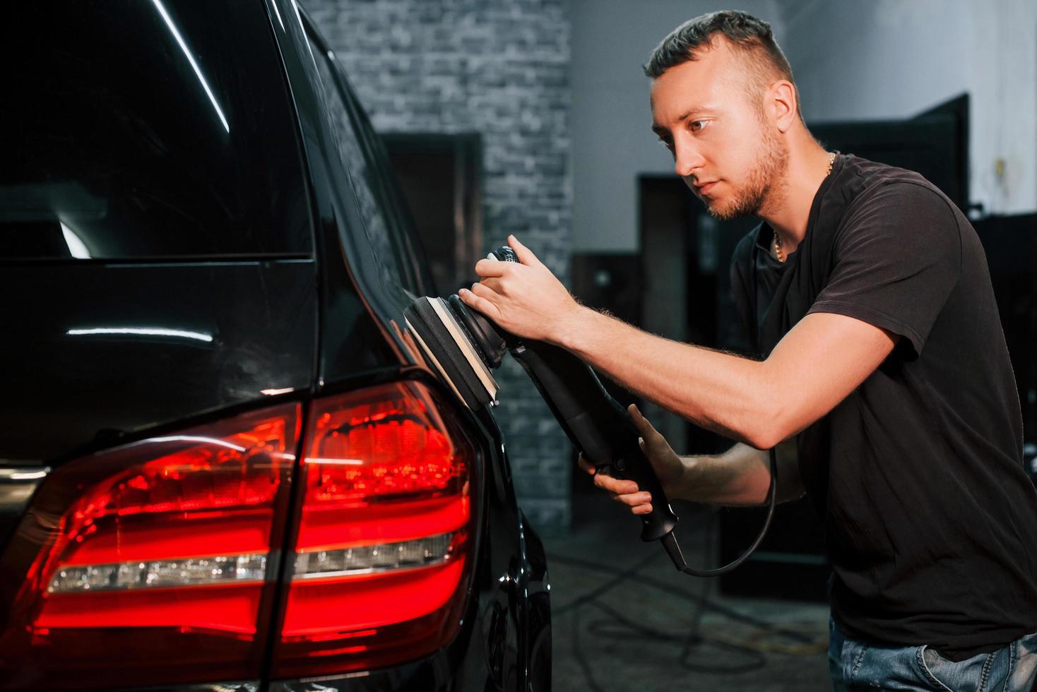 vent polijsten oppervlakte van voertuig. modern zwart auto- krijgen schoongemaakt door Mens binnen van auto wassen station foto