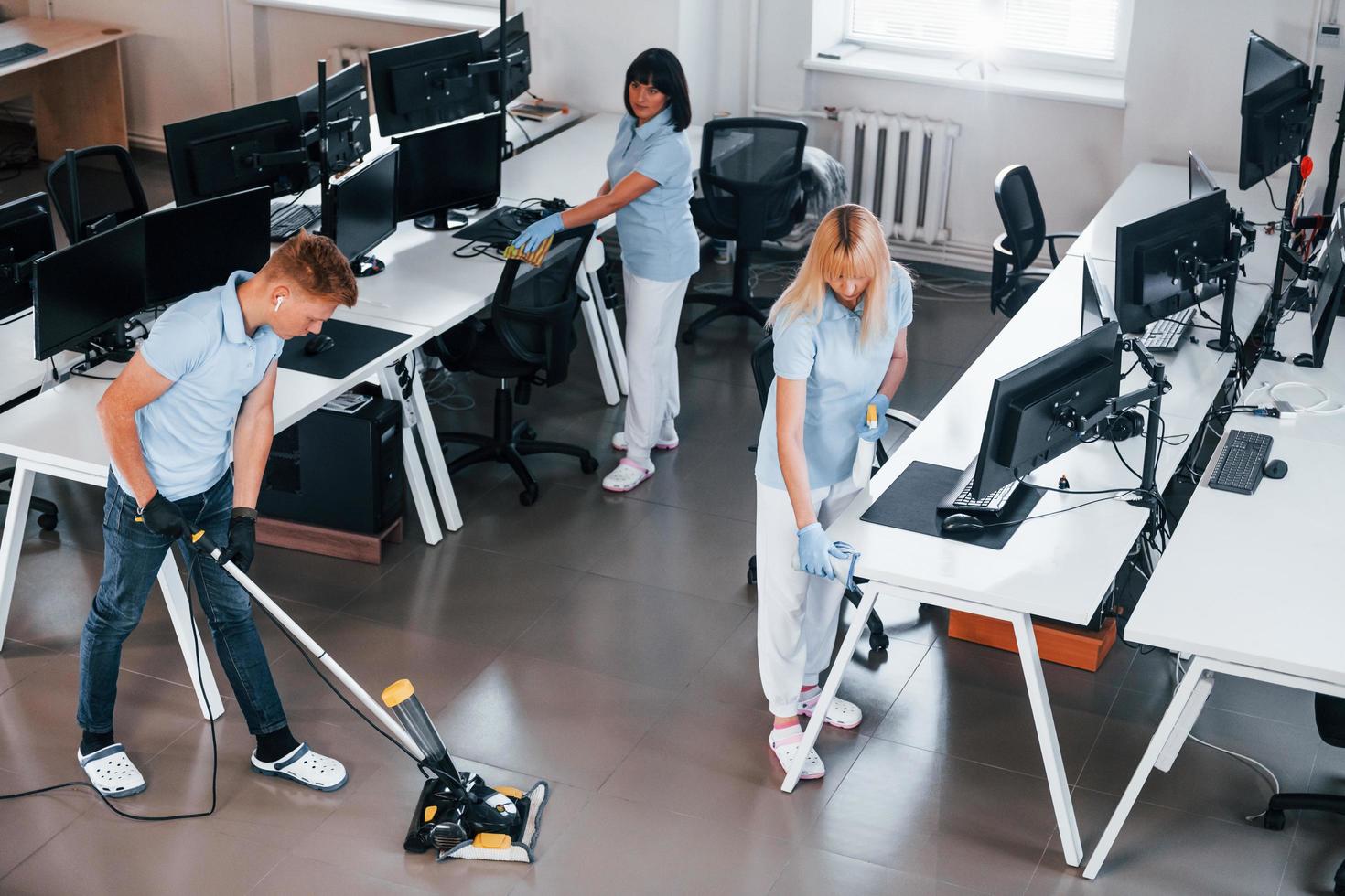 reinigt vloer. groep van arbeiders schoon modern kantoor samen Bij dag foto