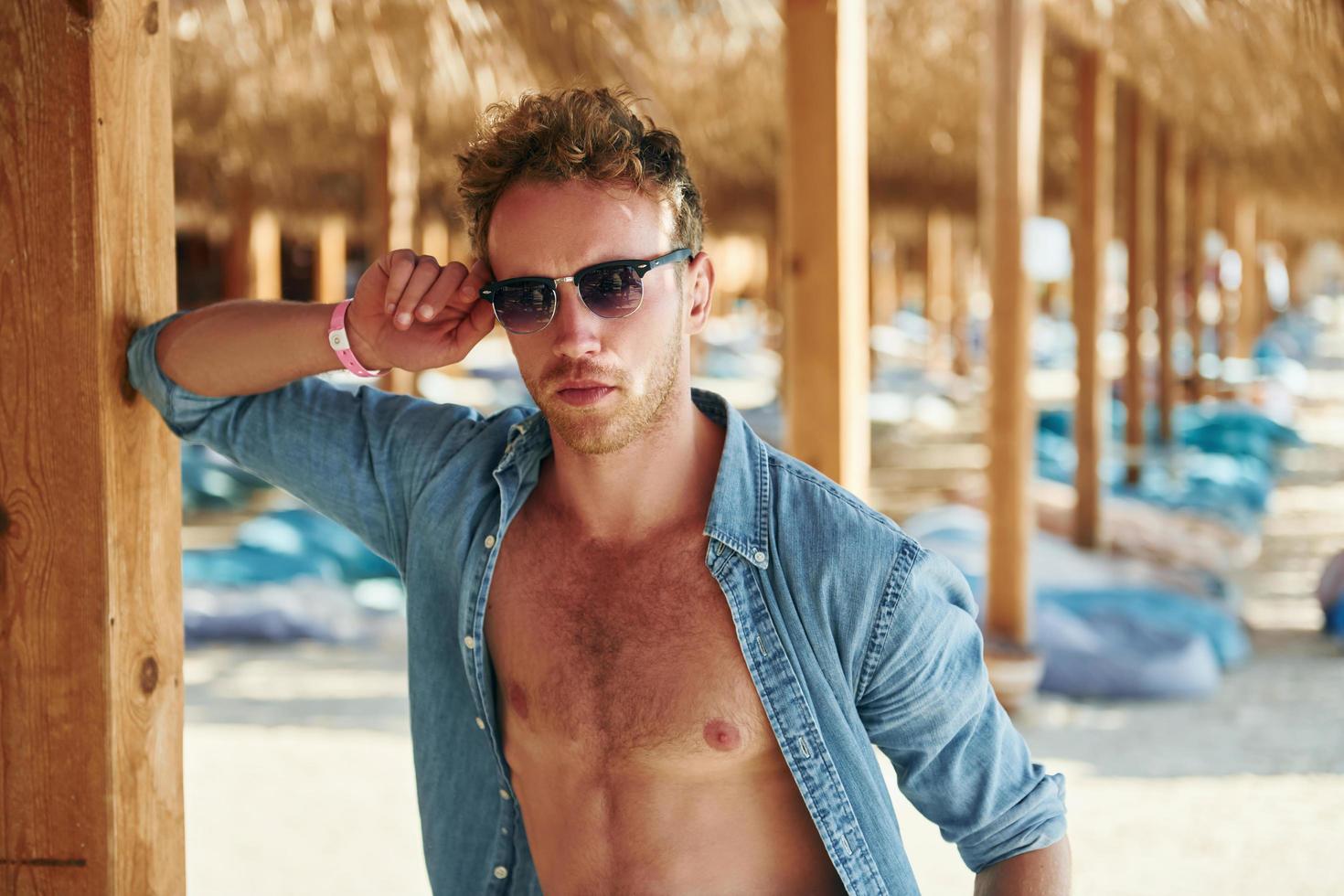 poseren voor een camera. jong Europese Mens hebben vakantie en genieten van vrij tijd Aan de strand van zee foto