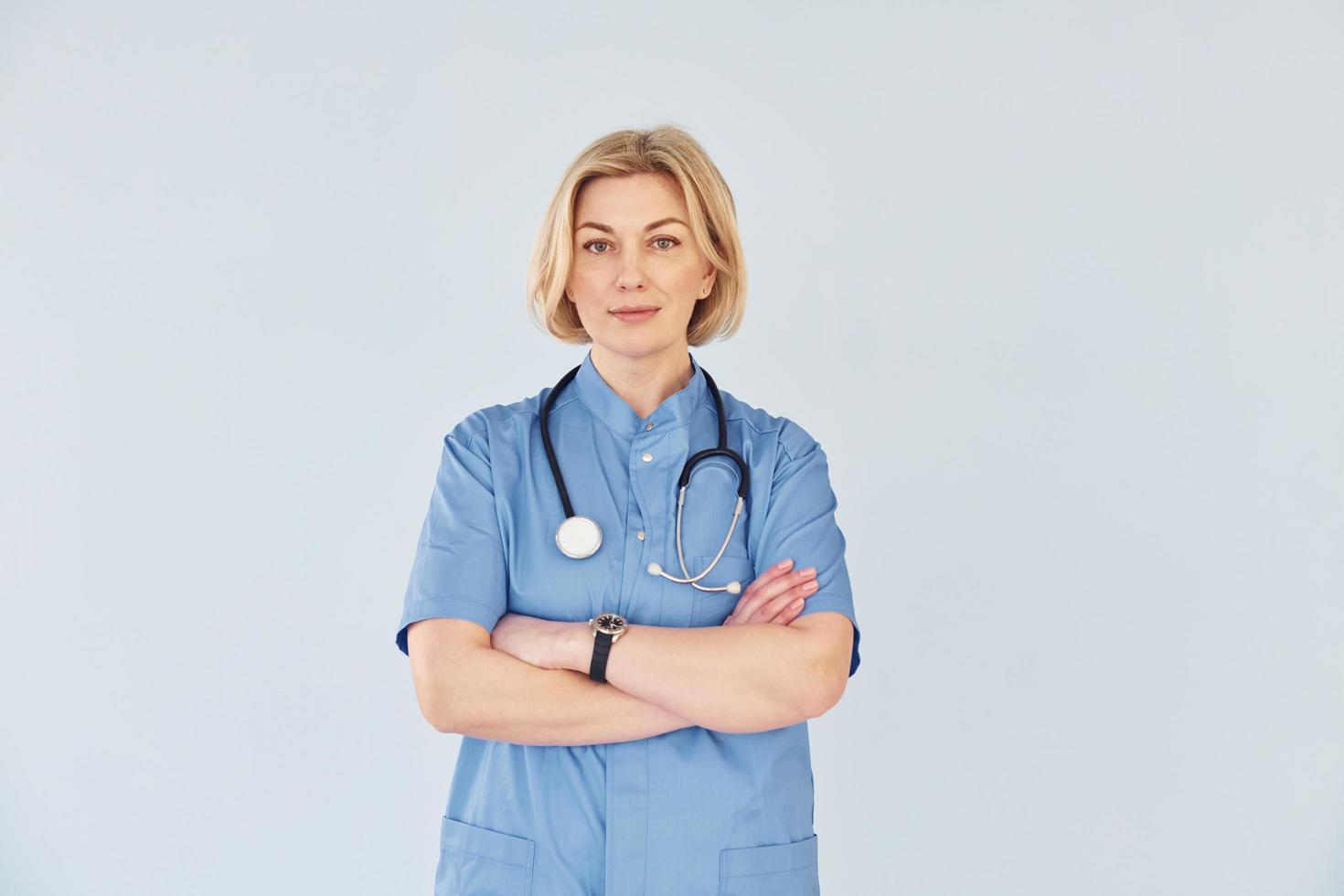 middelbare leeftijd professioneel vrouw dokter in uniform en met stethoscoop foto