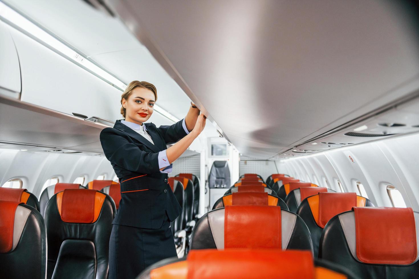 leeg stoelen. jong stewardess Aan de werk in de passagier vliegtuig foto