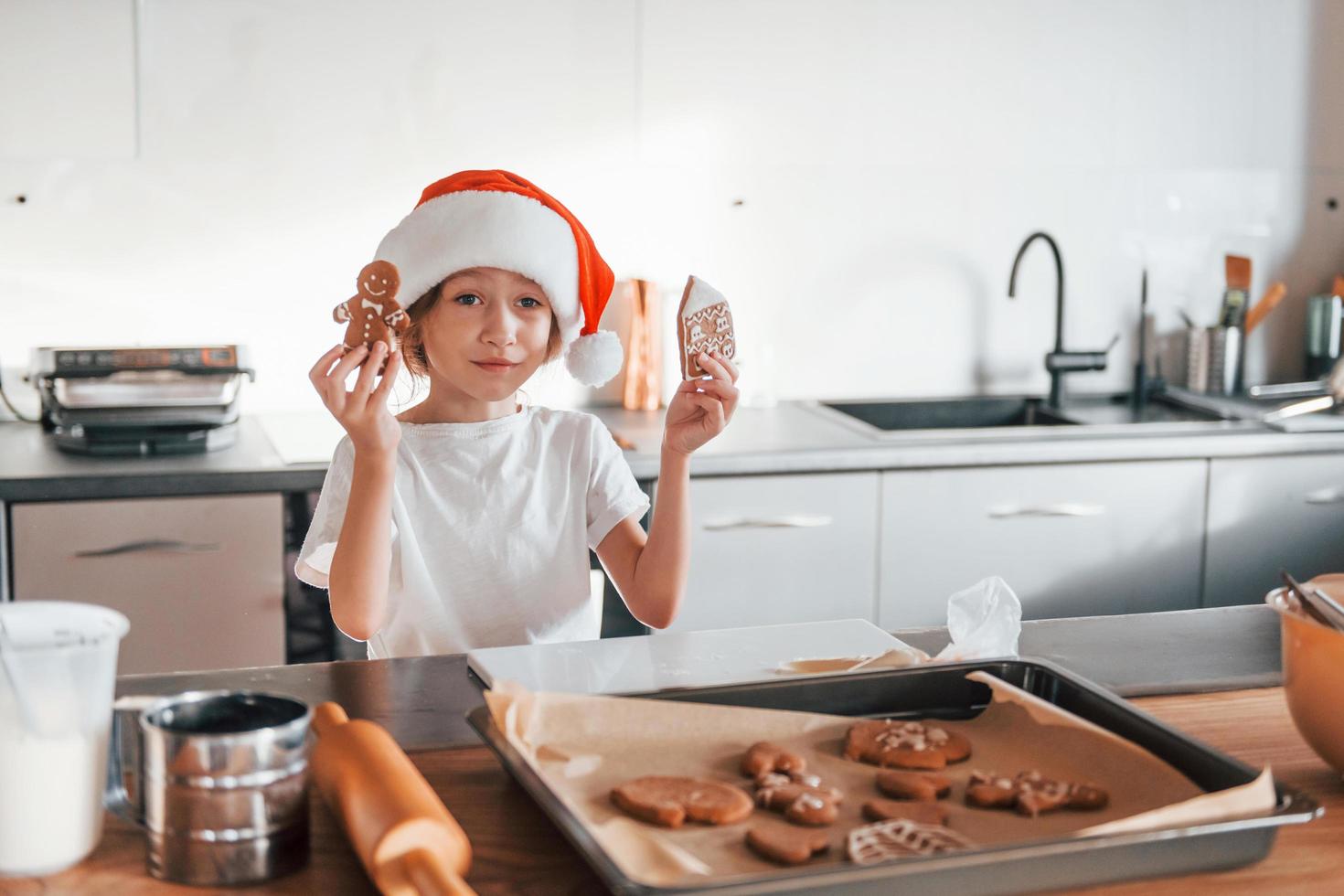 weinig meisje voorbereidingen treffen Kerstmis koekjes Aan de keuken foto