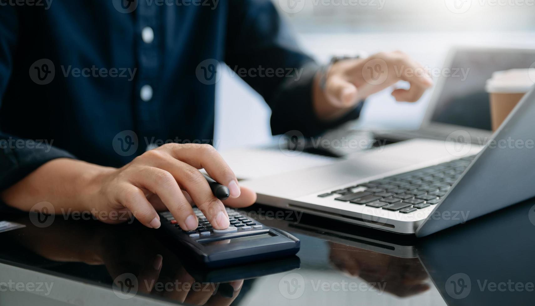dichtbij omhoog van zakenvrouw of accountant hand- typen laptop werken naar berekenen Aan bureau over kosten Bij huis kantoor. foto