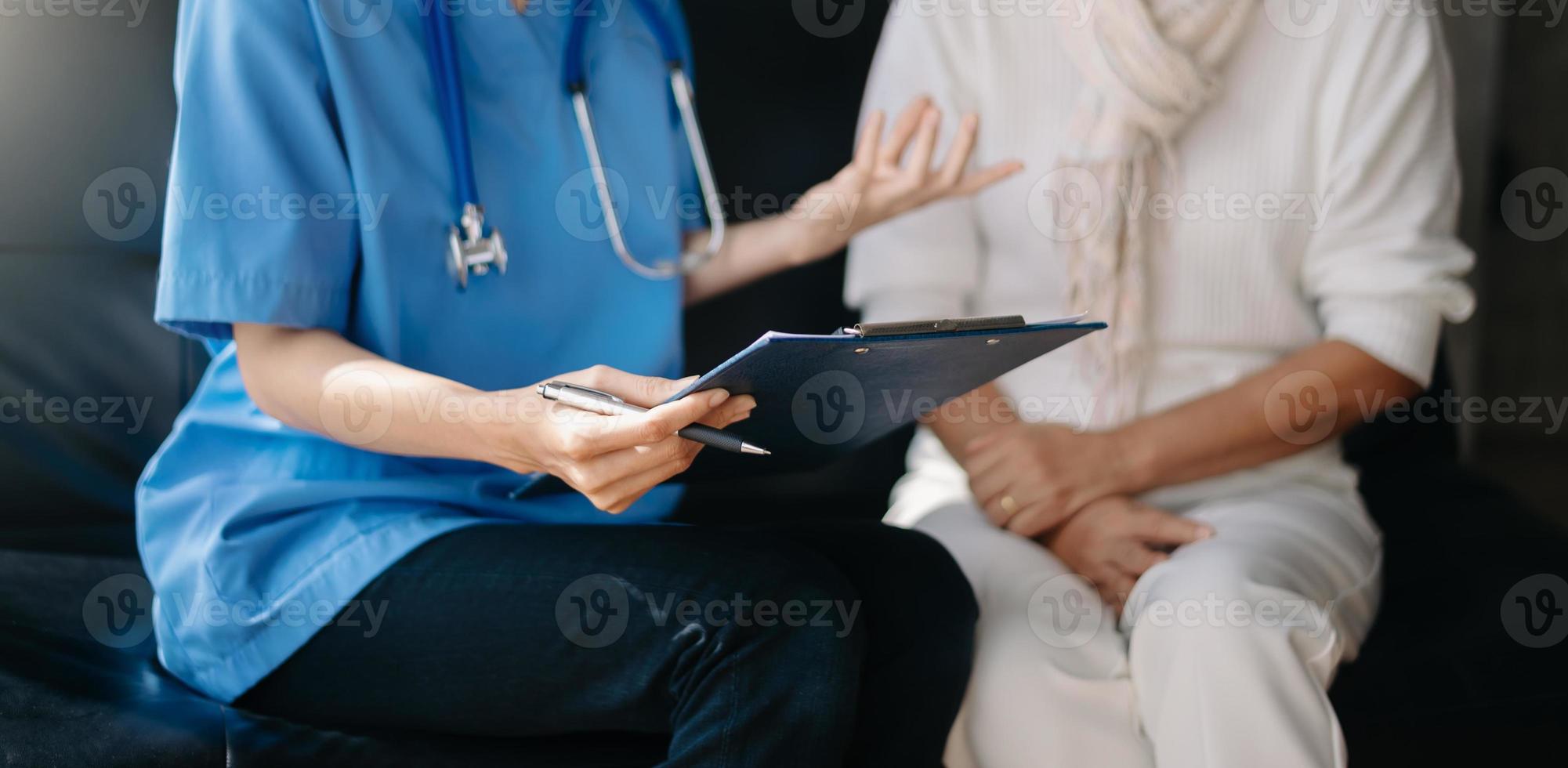 dokter en geduldig bespreken iets terwijl zittend Bij de tafel . geneeskunde en Gezondheid zorg concept. foto