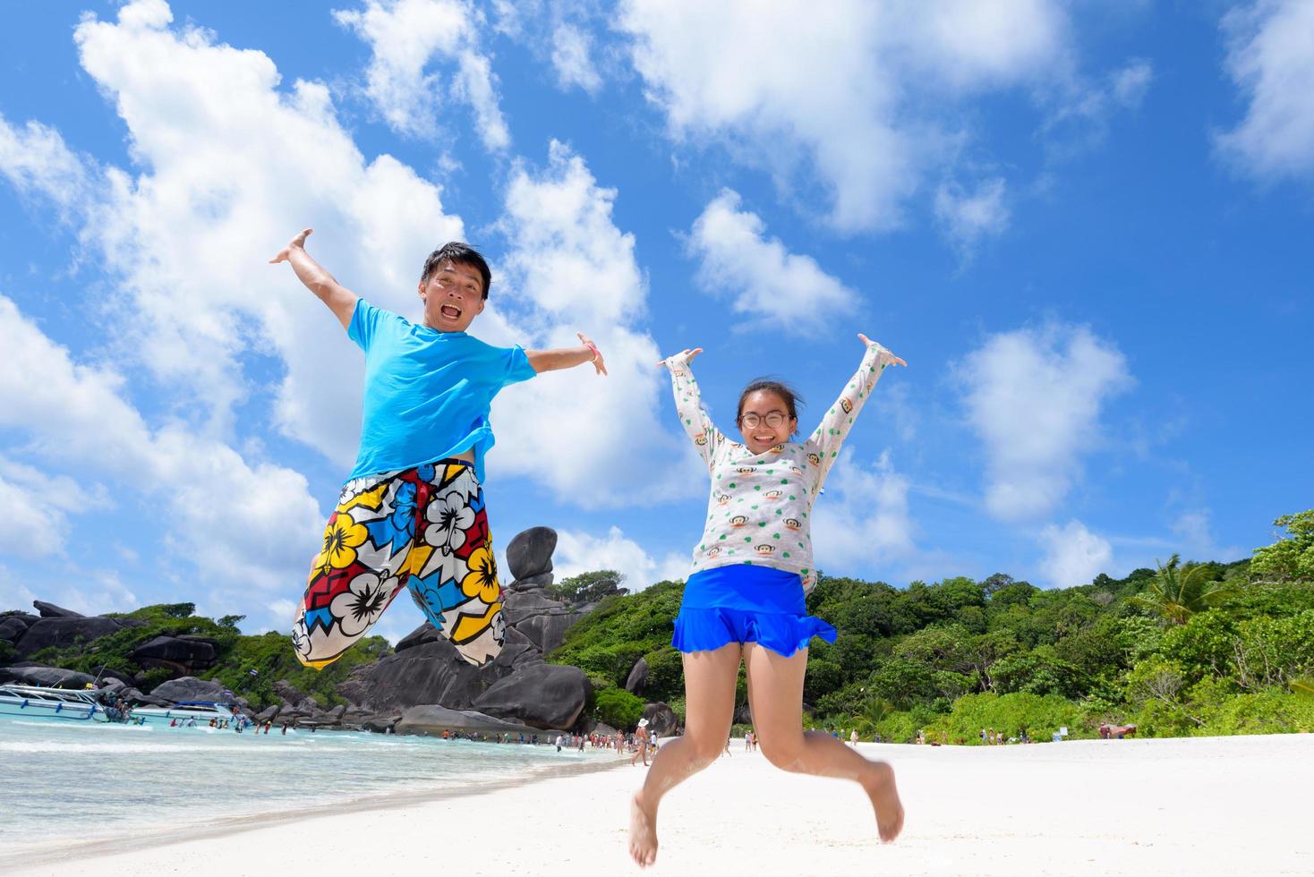 vader en dochter jumping Aan strand Bij Thailand foto