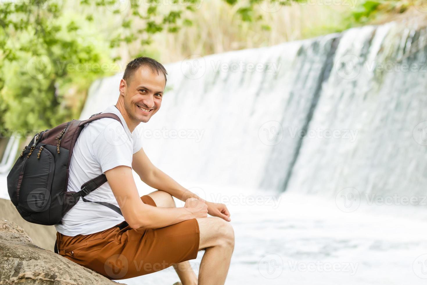 de vent is zittend Aan een klein waterval. foto