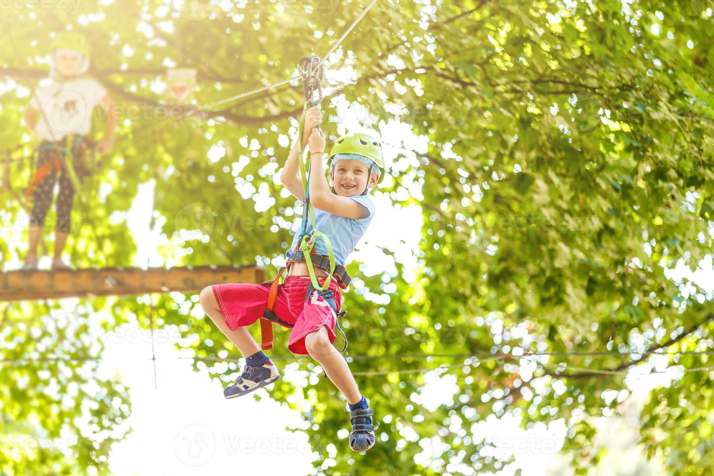 gelukkig weinig kinderen in een touw park Aan de hout achtergrond foto