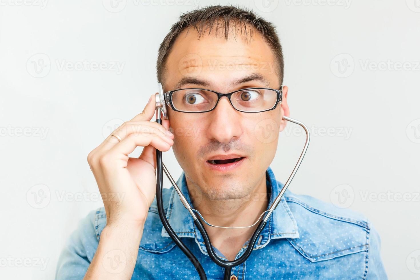 portret van jong vrolijk mannetje dokter in uniform met phonendoscope over- wit achtergrond foto