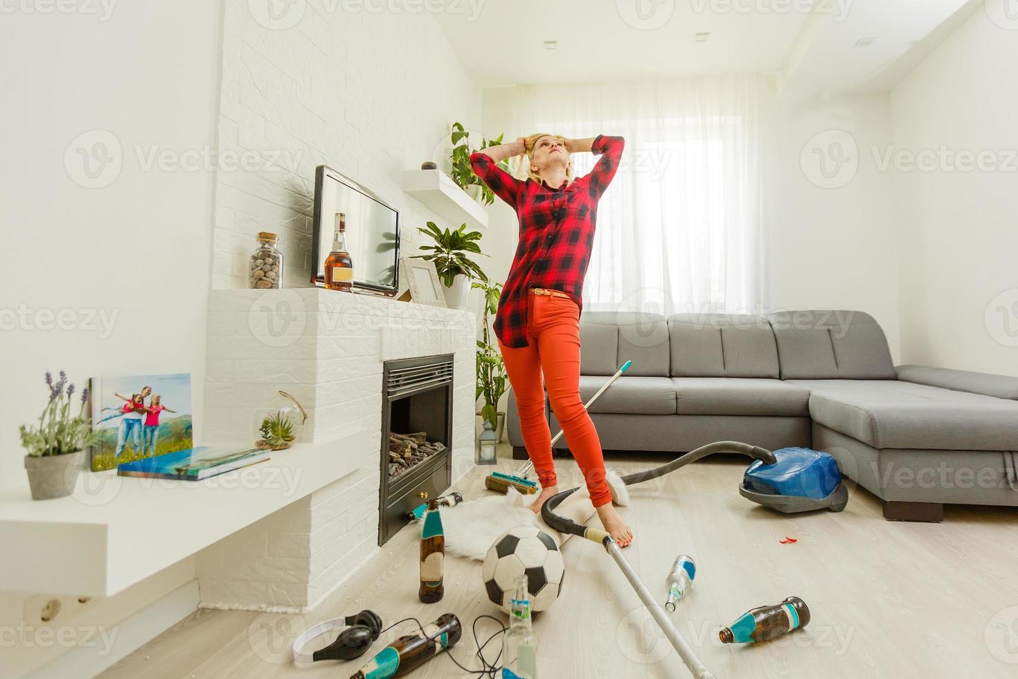 jong vrouw moe van voorjaar schoonmaak huis, het wassen verdieping met vacuüm schoonmaakster in rommelig kamer, kopiëren ruimte foto