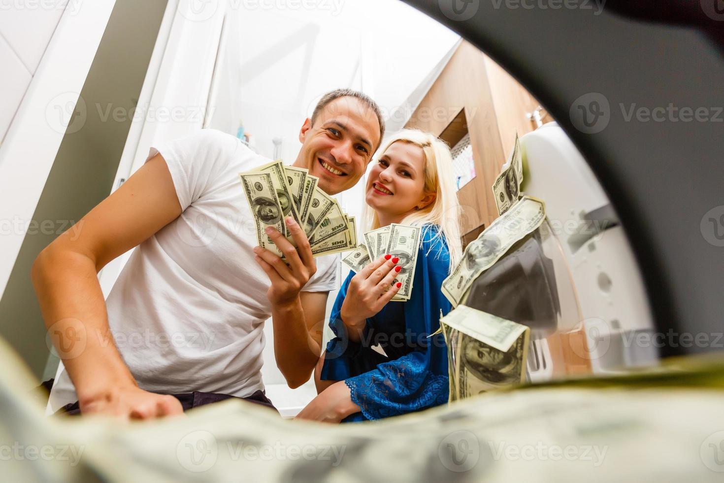vrouw zetten geld in het wassen machine, detailopname foto