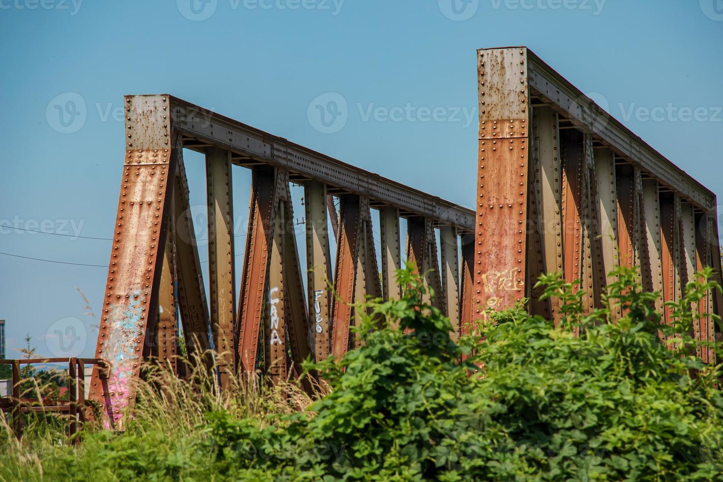 oud roestig brug over- de rivier. vervoer. oud metaal spoorweg brug. staal brug aan de overkant de rivier- tegen blauw lucht. foto