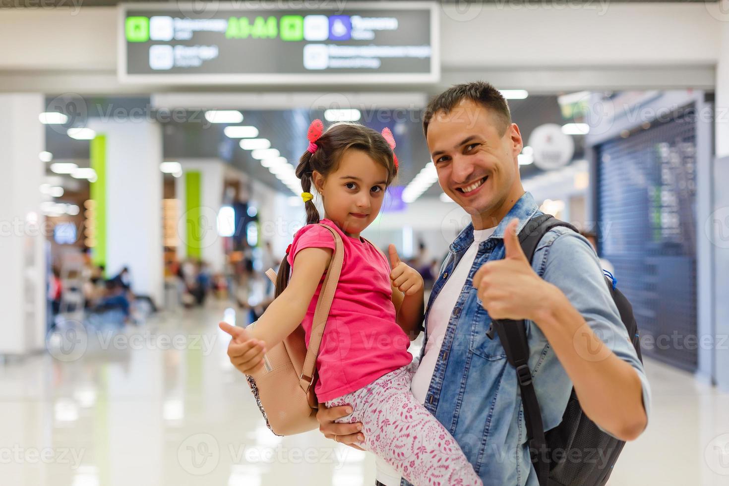 papa is omarmen meisje in de luchthaven hal met geluk. foto