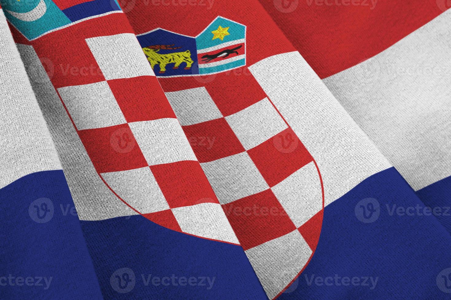 Kroatië vlag met groot vouwen golvend dichtbij omhoog onder de studio licht binnenshuis. de officieel symbolen en kleuren in banier foto