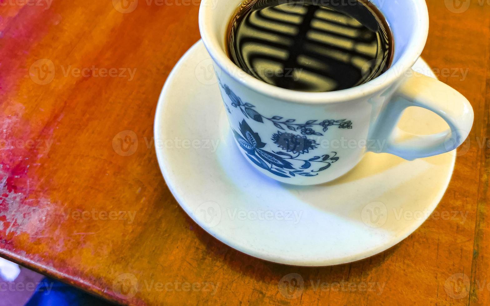 blauw wit kop pot met zwart koffie houten tafel Mexico. foto