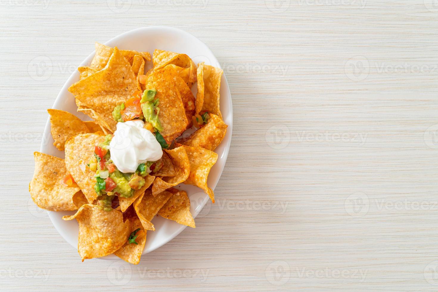 nachos tortillachips met jalapeno, guacamole, tomatensalsa en dip foto