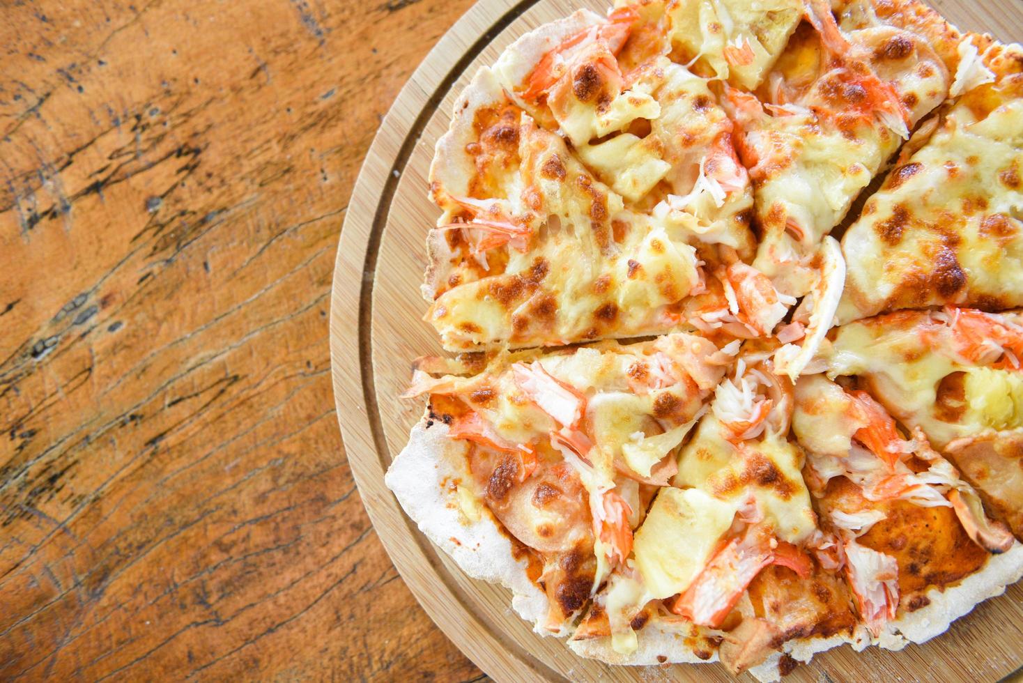 pizza kaas plak Aan houten dienblad en geserveerd Aan een houten tafel , top visie eigengemaakt gebakje pizza Italiaans is gekookt traditioneel voedsel foto