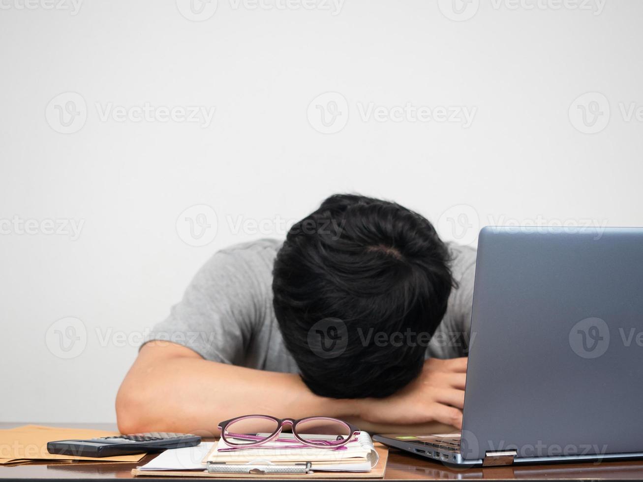 verdrietig Mens geprobeerd van werken hoofd naar beneden Aan werkplaats tafel wit achtergrond foto