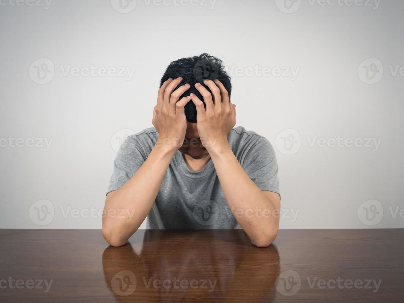 droefheid Mens houden zijn hoofd zittend Bij tafel foto