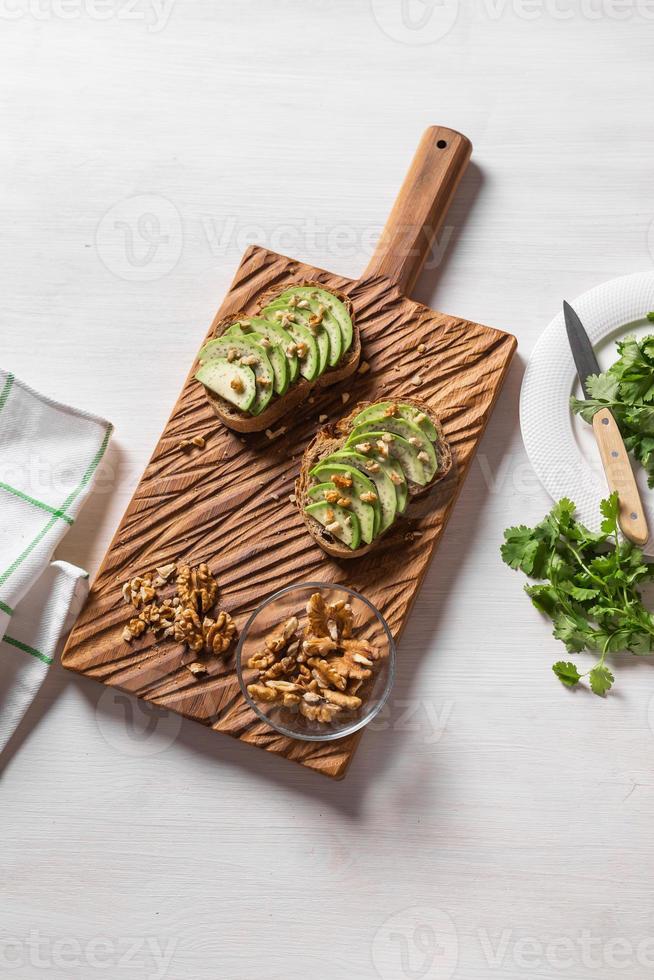 avocado belegd broodje Aan donker rogge brood gemaakt met vers gesneden avocado's van bovenstaande. ontbijt concept. top visie. foto