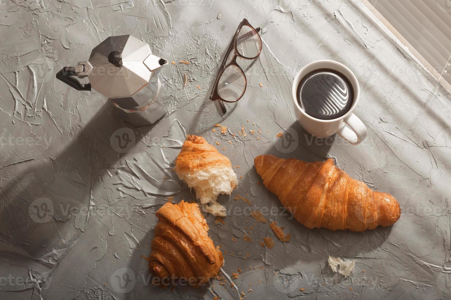 ontbijt met croissant Aan snijdend bord en zwart koffie. ochtend- maaltijd en ontbijt concept. top visie. foto