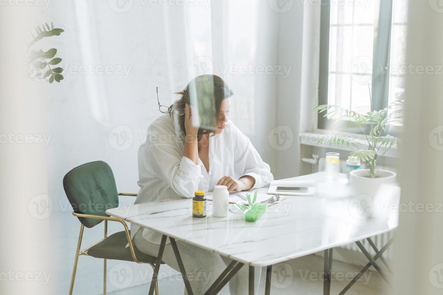 denken brunette vrouw dokter voedingsdeskundige plus grootte in wit overhemd werken Aan tafel met huis fabriek in helder modern kantoor kamer foto