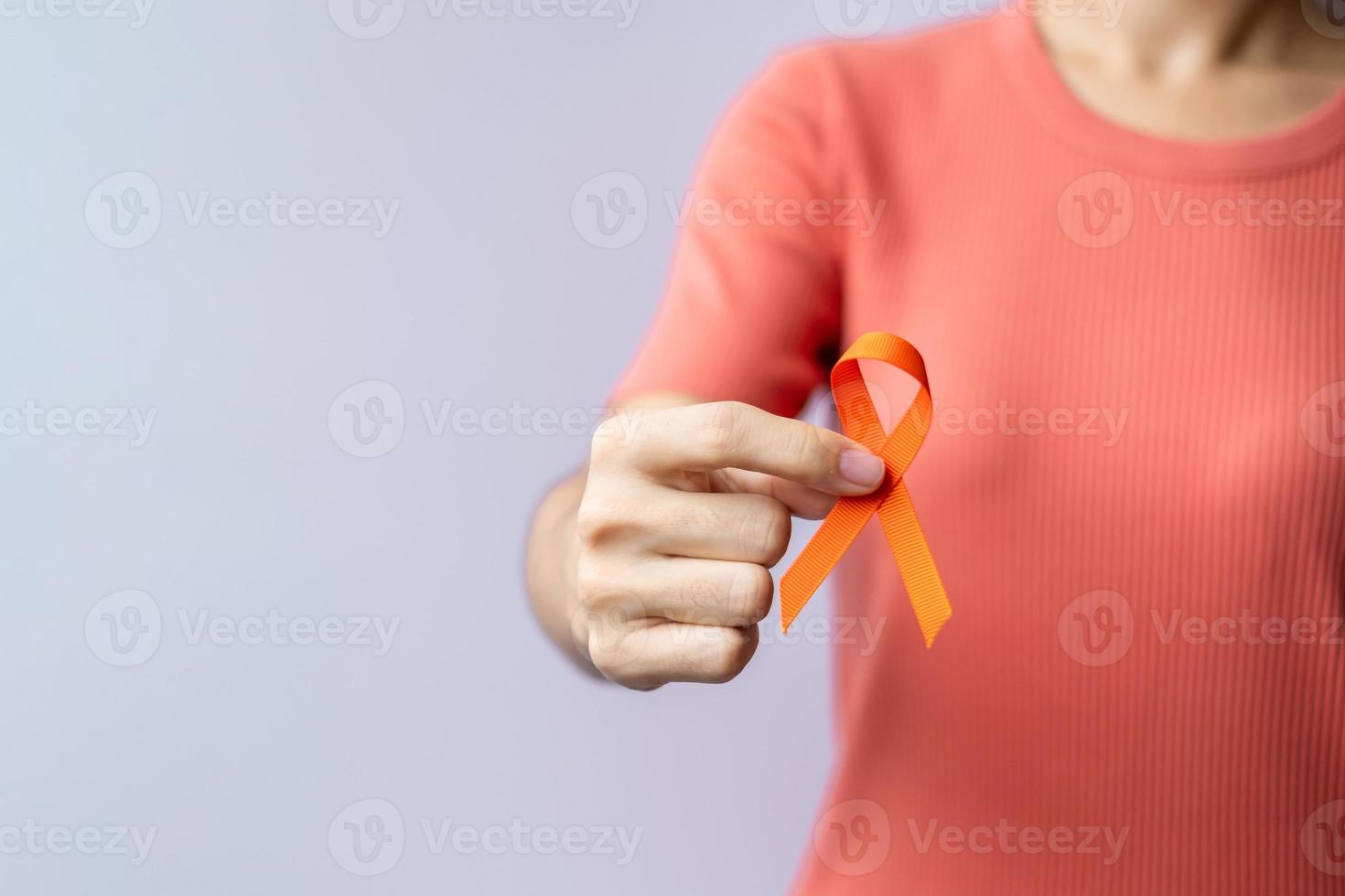 oranje lint voor leukemie, nierkankerdag, wereld multiple sclerose, crps, zelfverwondingsmaand. gezondheidszorg en woord kanker dag concept foto