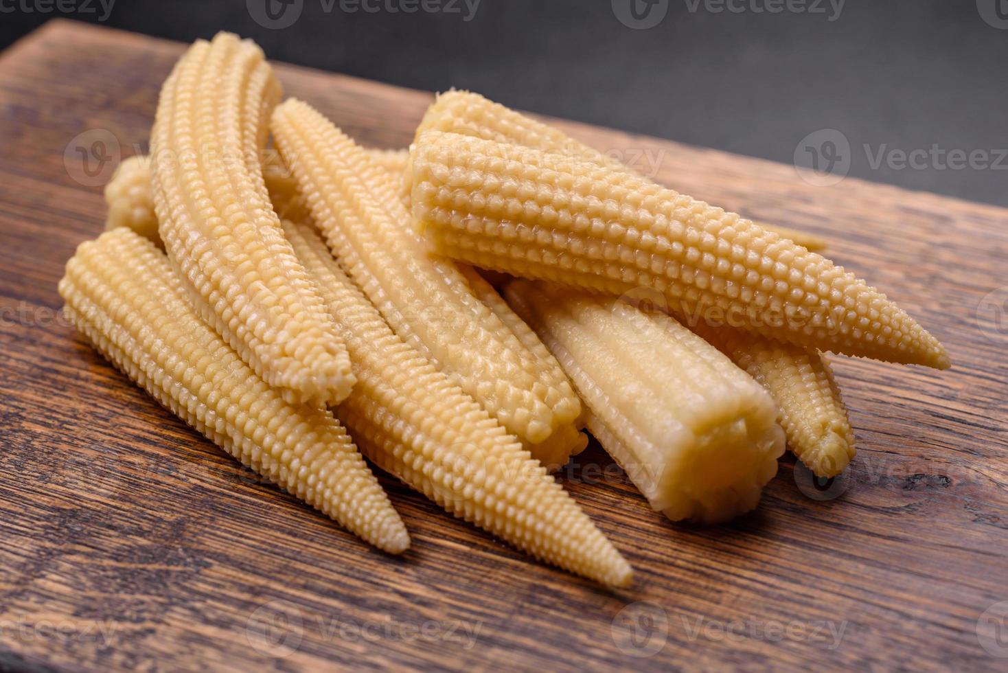 een bundel van klein wit ingeblikt maïs Aan een donker beton achtergrond foto