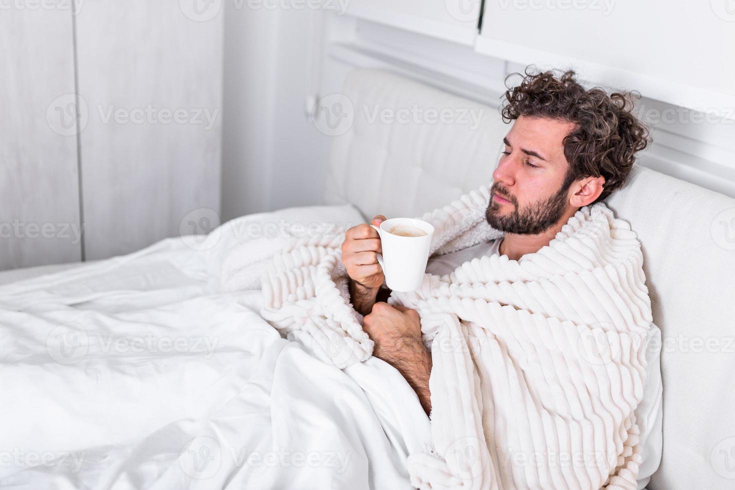 ziek dag Bij huis. knap Mens heeft koorts en gemeenschappelijk koud. hoesten. detailopname van jong Mens gevangen verkoudheid of griep ziekte. portret van ongezond Mens gevoel pijn in keel en drinken heet drank. foto