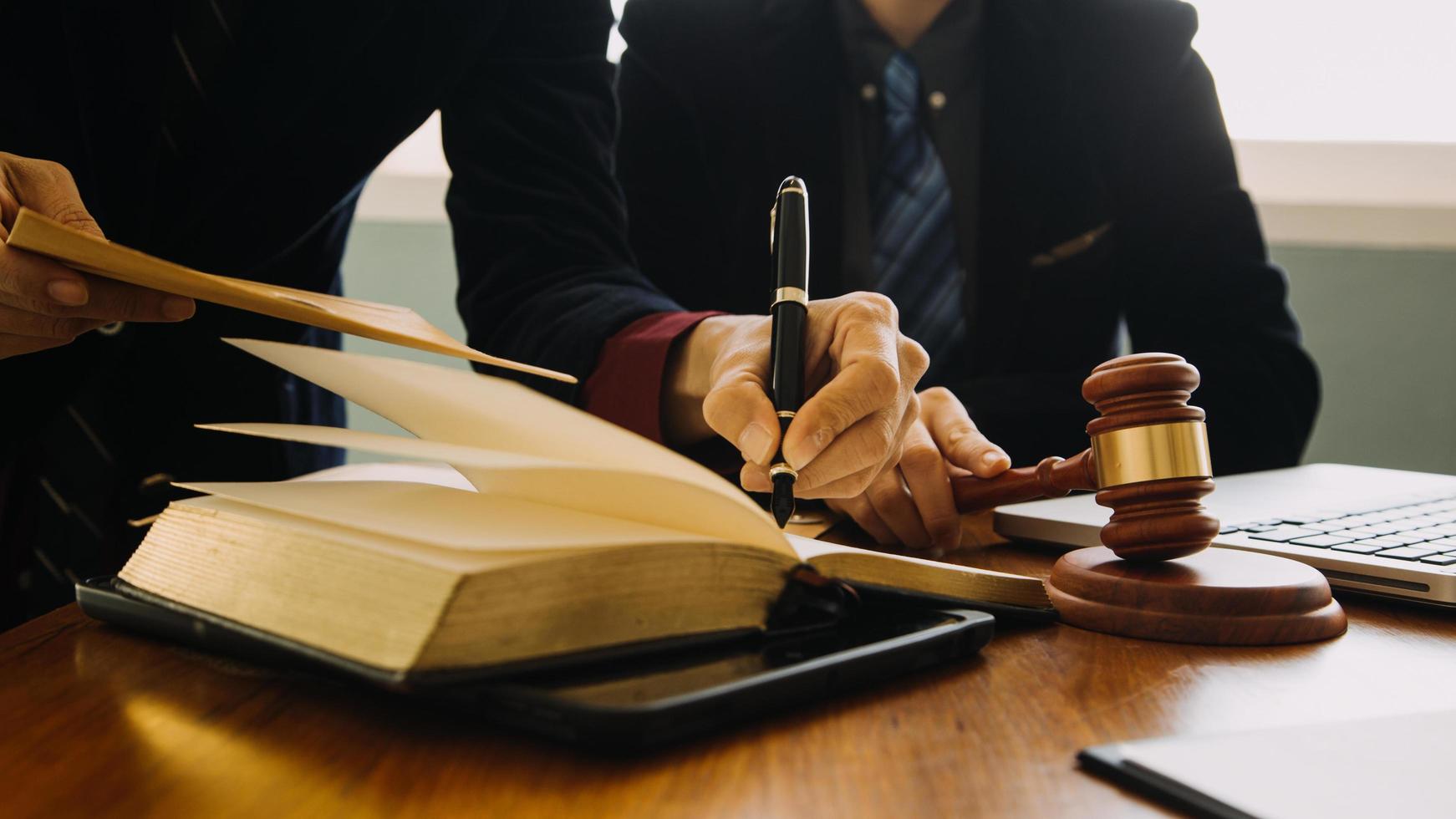 zaken en advocaten bespreken contractpapieren met koperen schaal op bureau in kantoor. wet, juridische diensten, advies, rechtvaardigheid en wet concept foto met film grain effect