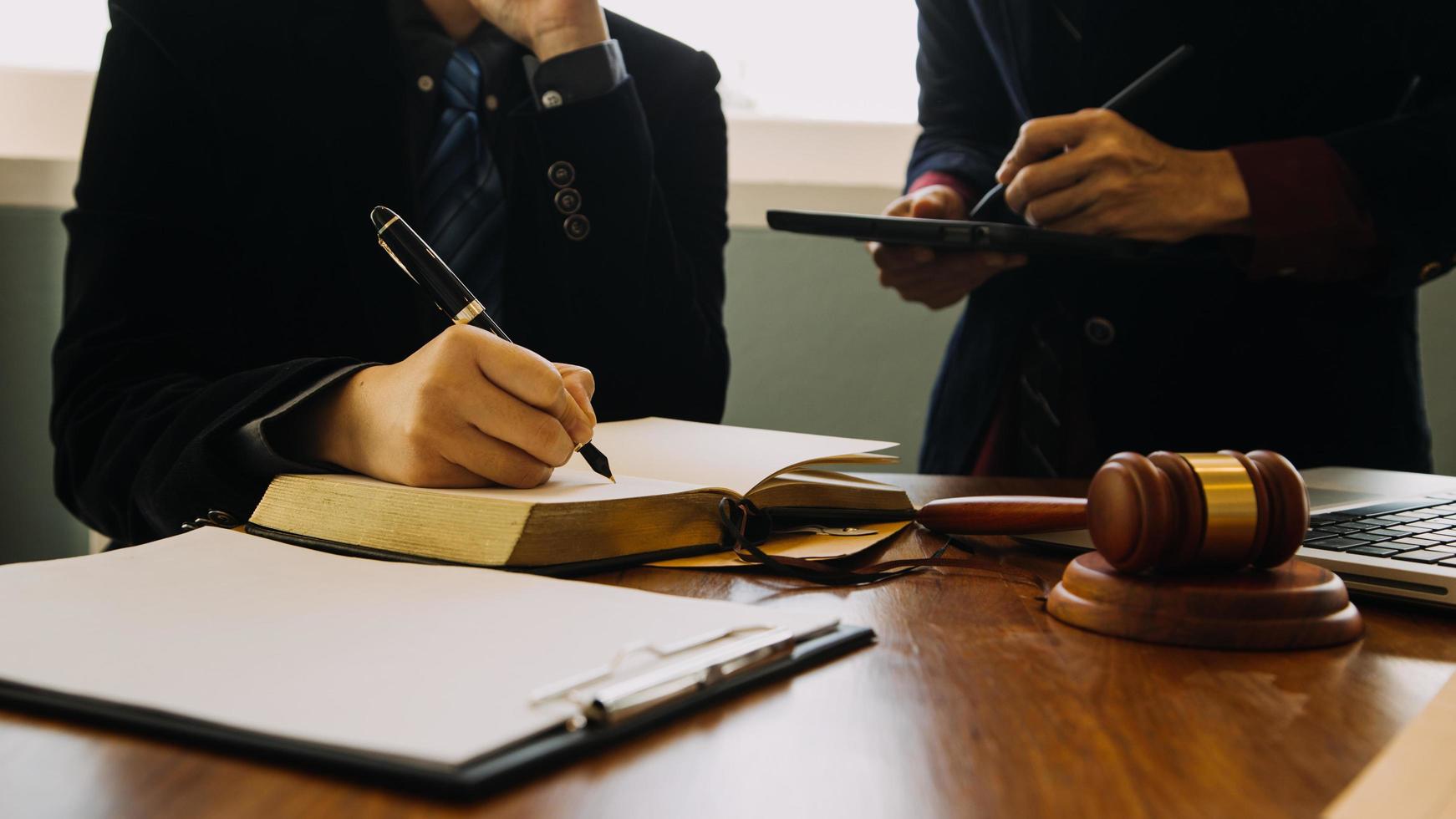 zaken en advocaten bespreken contractpapieren met koperen schaal op bureau in kantoor. wet, juridische diensten, advies, rechtvaardigheid en wet concept foto met film grain effect