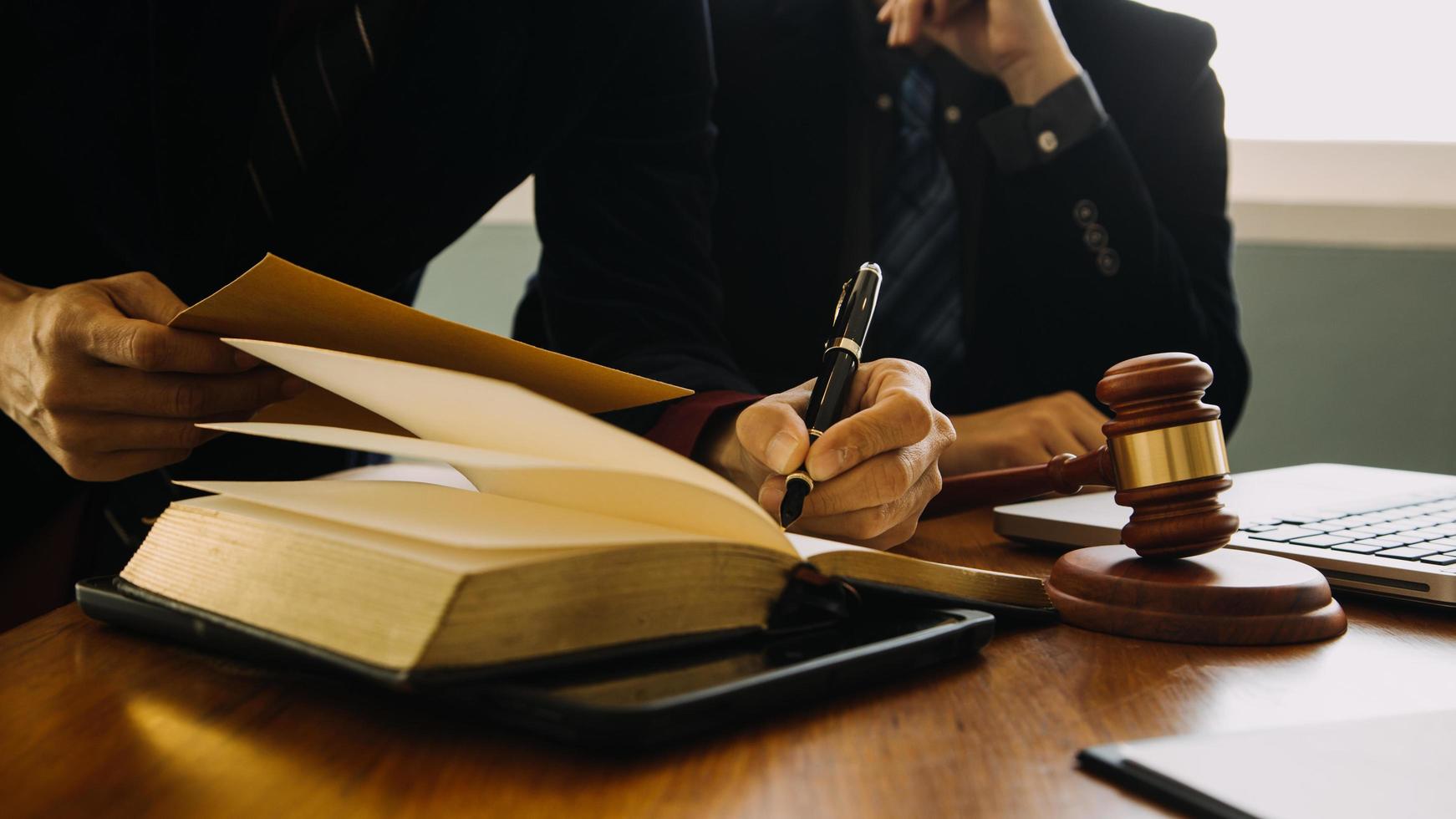 zaken en advocaten bespreken contractpapieren met koperen schaal op bureau in kantoor. wet, juridische diensten, advies, rechtvaardigheid en wet concept foto met film grain effect