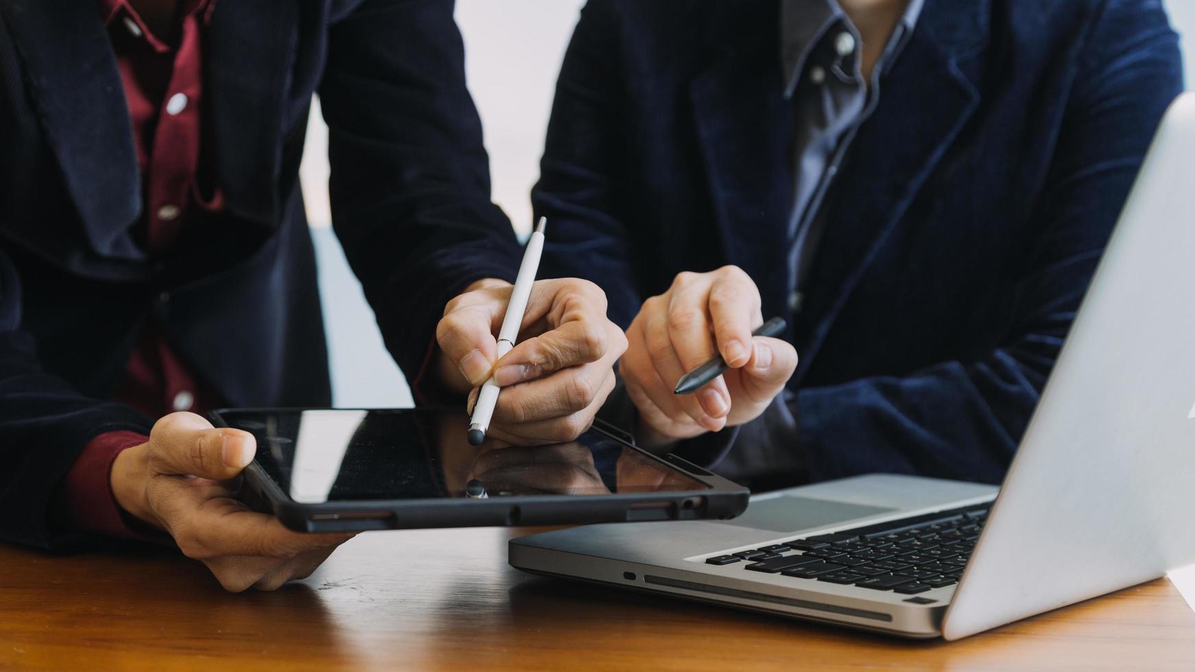 Aziatisch collega's Mens en vrouw bespreken en werken met laptop computer Aan kantoor bureau in de kantoor foto