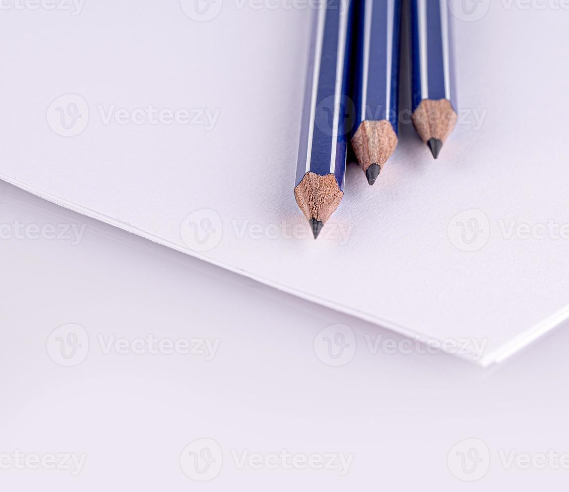 selectief focus. drie potloden Aan wit papier bladen. dichtbij omhoog foto