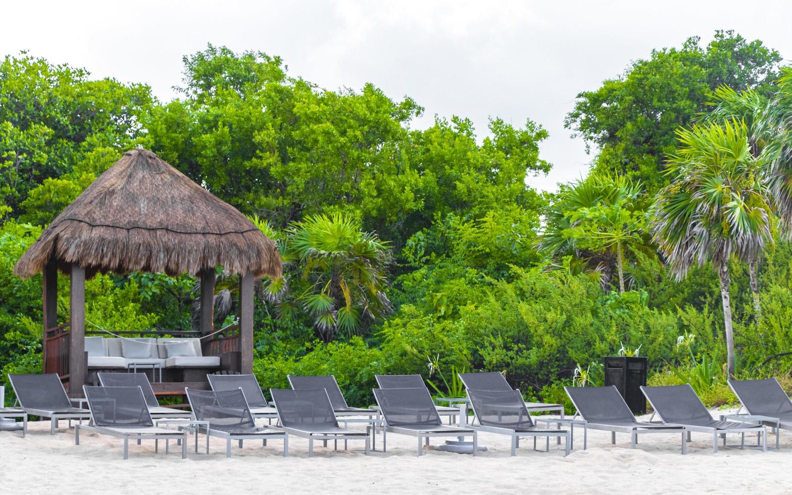 palmen parasols ligstoelen strandresort playa del carmen mexico. foto