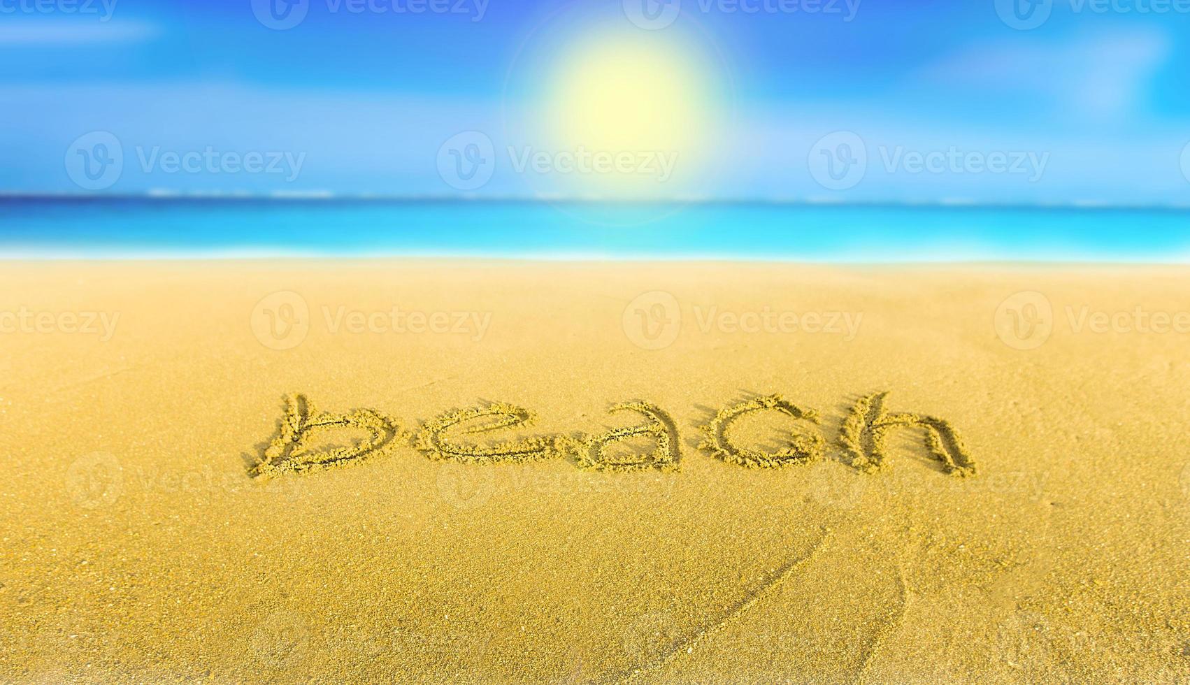 het gele zand op het strand blauwe zee en het opschrift strand foto