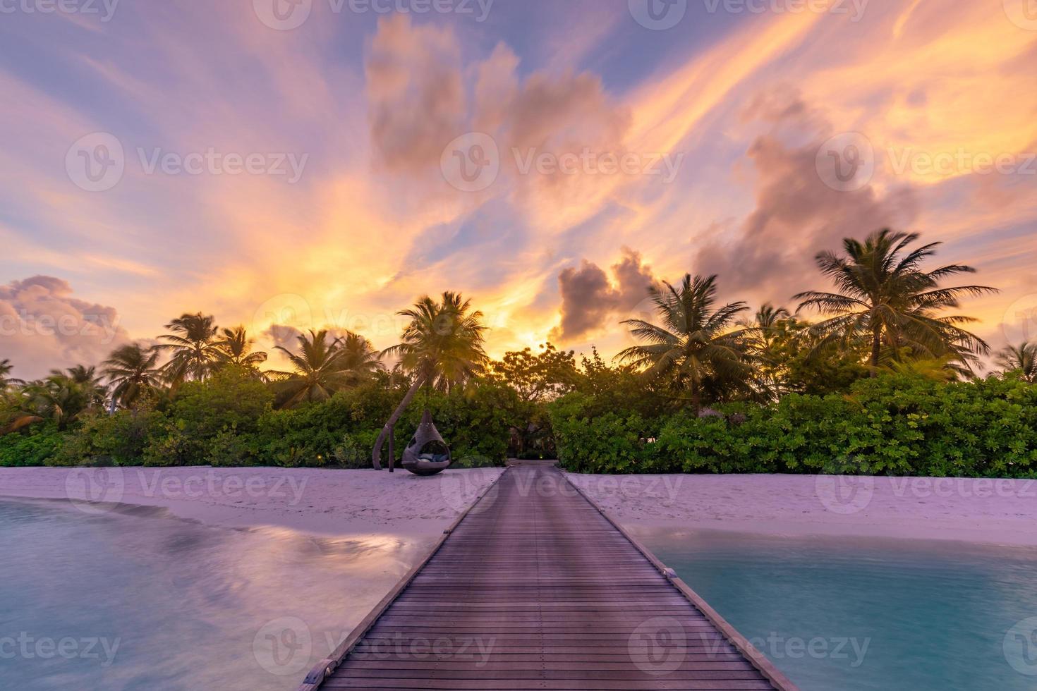 zonsondergang op het eiland Malediven, luxe watervilla's resort en houten pier. mooie lucht en wolken en strand achtergrond voor zomervakantie vakantie en reizen concept. paradijs zonsondergang landschap foto